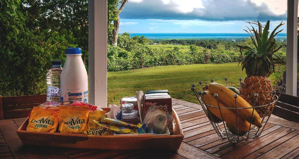 una cesta de comida y una botella de leche y una piña en Gîte Noasol, en Sainte-Rose