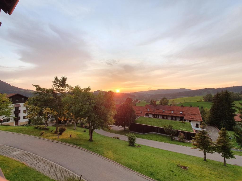 une vue sur une route avec le coucher du soleil en arrière-plan dans l'établissement Ferienwohnung Nicole, à Missen-Wilhams