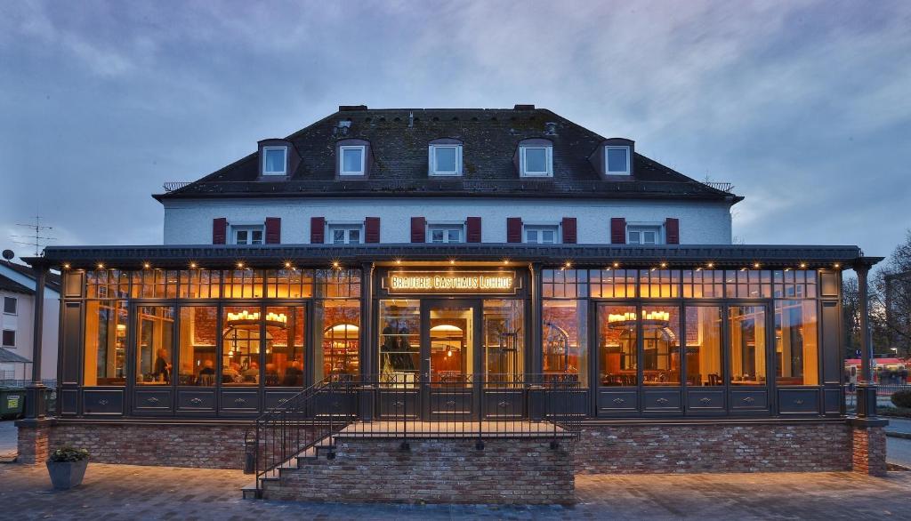 un bâtiment avec beaucoup de fenêtres dans l'établissement Brauerei Gasthaus Lohhof, à Unterschleissheim