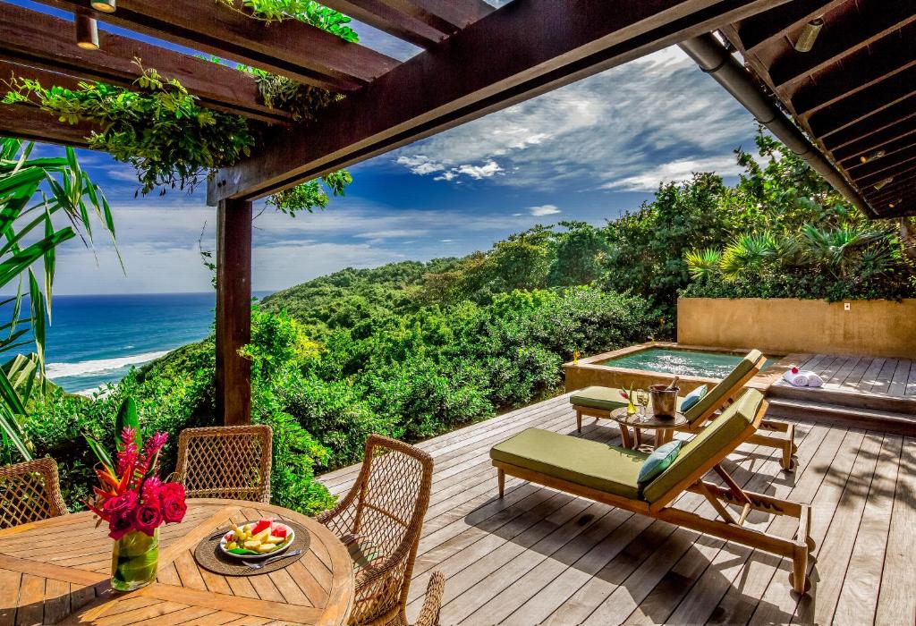 une terrasse avec une table et des chaises et l'océan dans l'établissement Royal Isabela, à Isabela