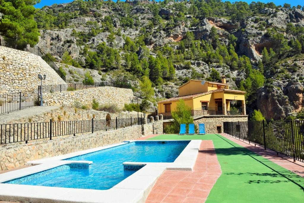 una casa con una piscina con una montaña en el fondo en Casas Rurales Mirador del Rio Zumeta, en Santiago de la Espada