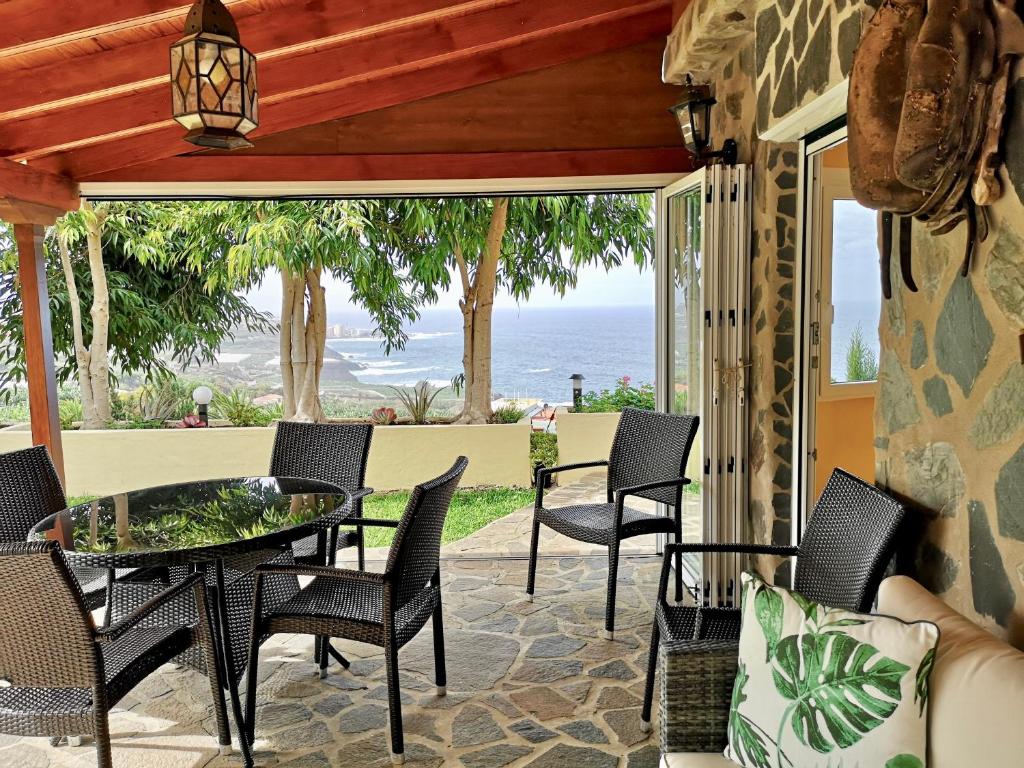 eine Terrasse mit einem Tisch, Stühlen und Meerblick in der Unterkunft Ancon Beach House in El Rincón