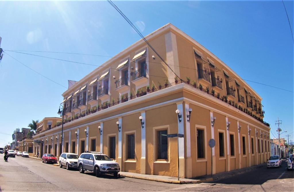 a building on a street with cars parked in front of it at Hotel America in Colima