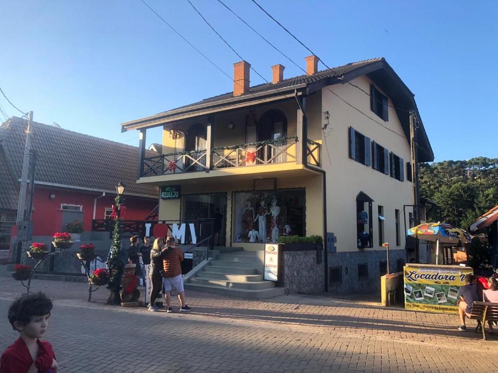 un edificio con gente parada fuera de él en Banyvas Chalés, en Monte Verde