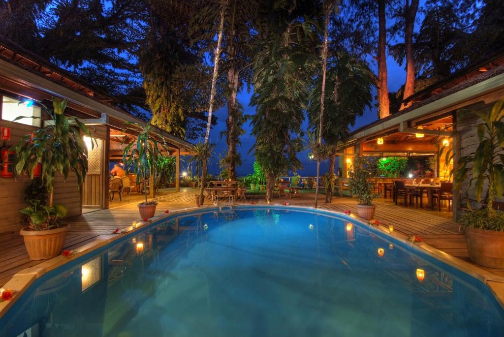 una piscina en una terraza con una casa en Walindi Plantation Resort, en Kimbe