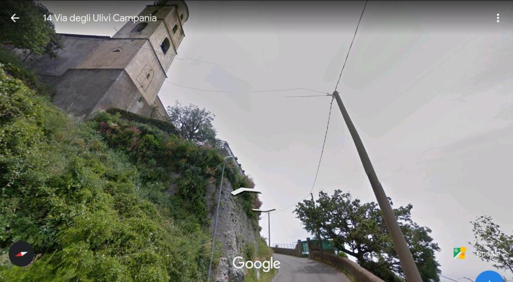 a street sign on a hill next to a building at GIARDINO SUL MARE in Amalfi