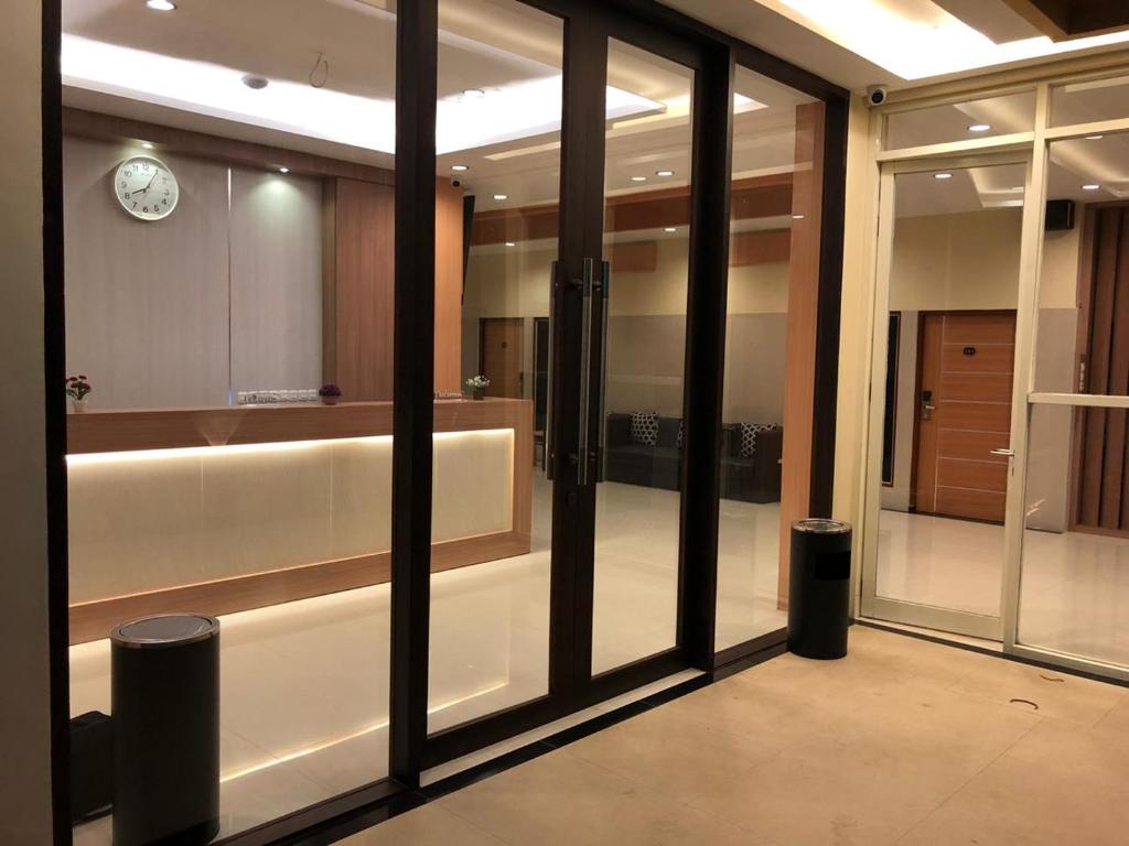 a room with glass doors and a clock on the wall at LCR HOTEL in Ende