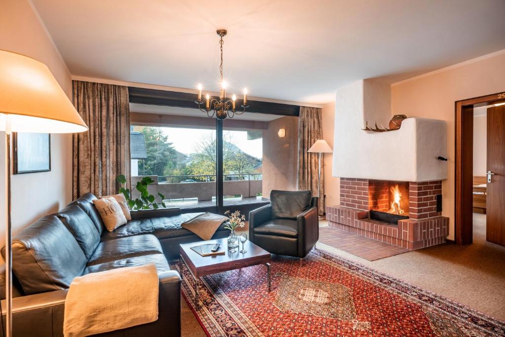 a living room with a leather couch and a fireplace at Aparthotel Andreas Hofer in Kufstein