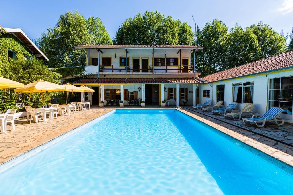 a swimming pool in front of a house at Pousada Cesar in Santo Antônio do Pinhal