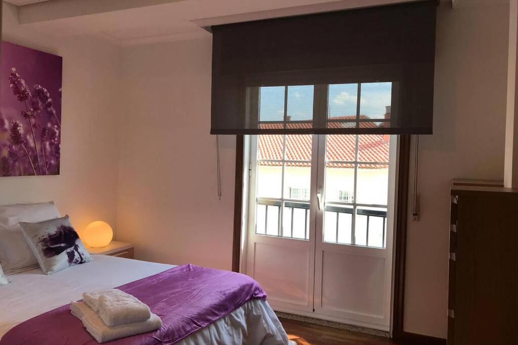 una camera con un letto e una grande finestra di Magnifica casa con garaje muy bien comunicada a Santiago de Compostela