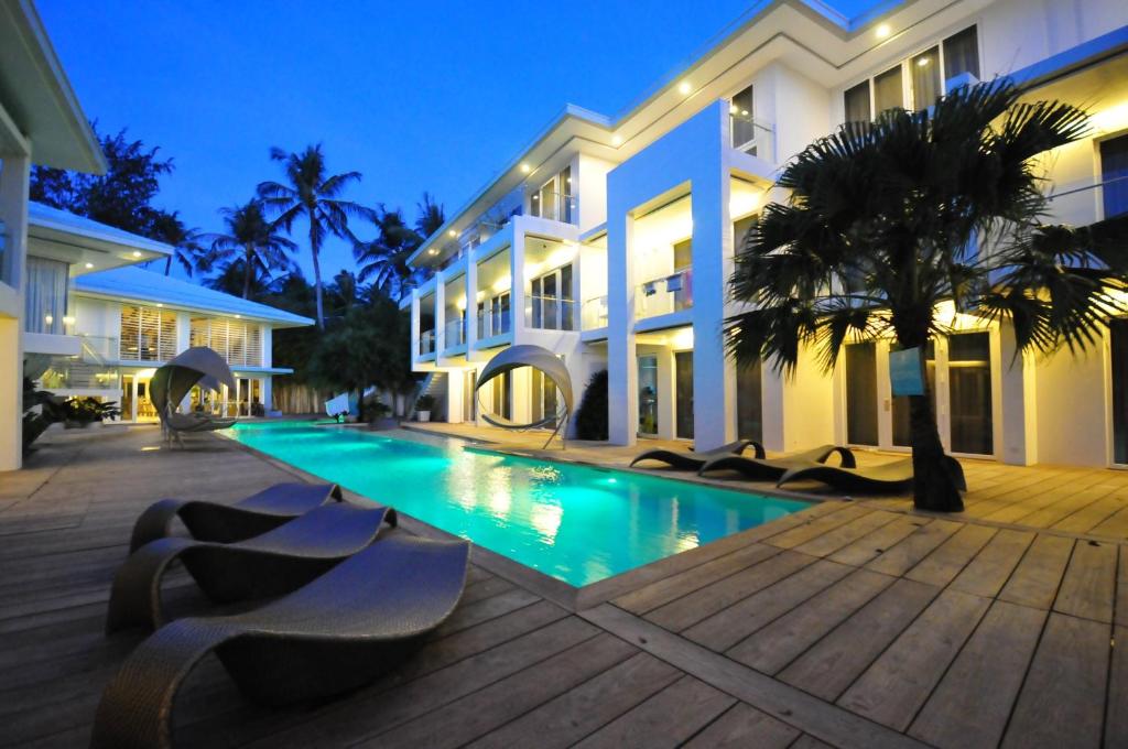 a villa with a swimming pool in front of a building at Astoria Boracay in Boracay