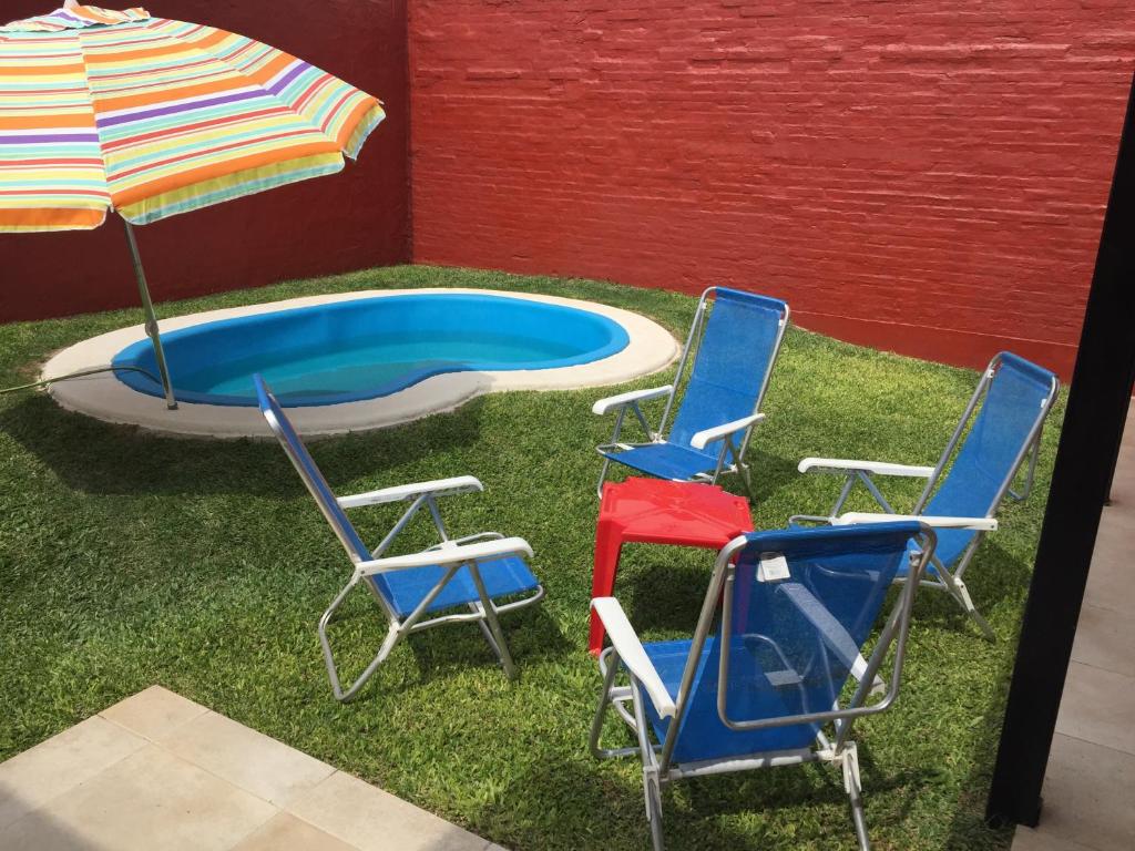 three chairs and an umbrella next to a pool at 9.9 in Santa Fe