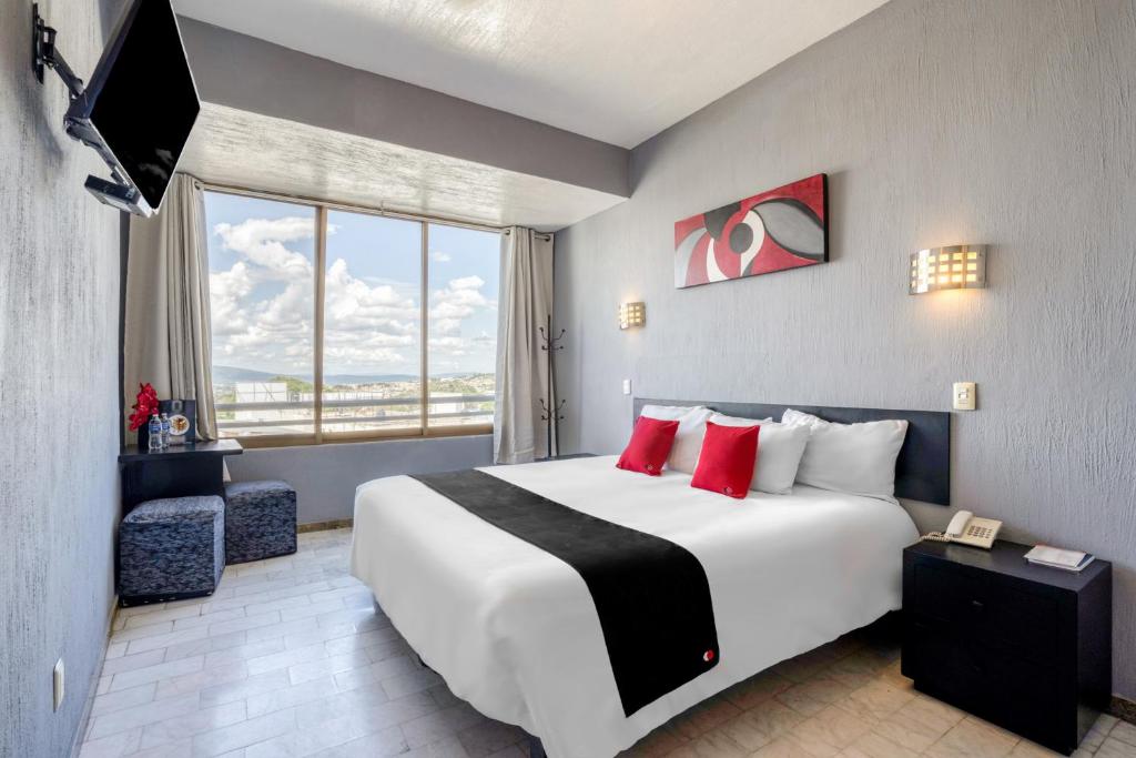 Habitación de hotel con cama grande y ventana grande. en Guadalajara Express Tonala, en Guadalajara