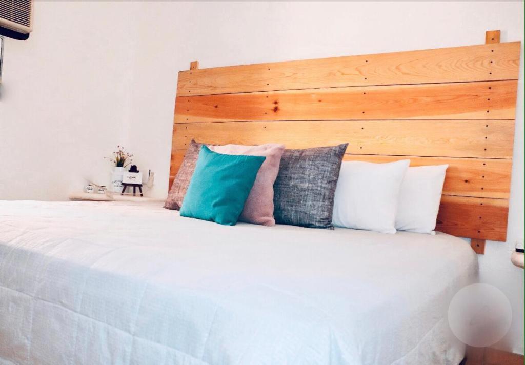 1 dormitorio con 1 cama blanca grande con almohadas en Habitaciones Samy, en San Francisco
