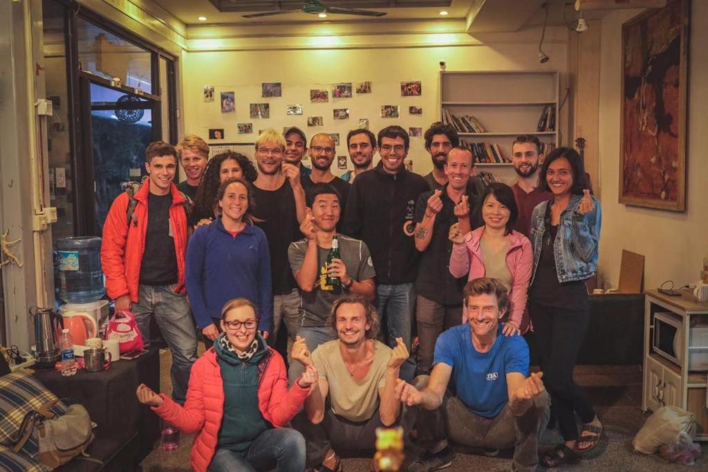 een groep mensen die poseren voor een foto in een kamer bij Climbers Inn Yangshuo in Yangshuo