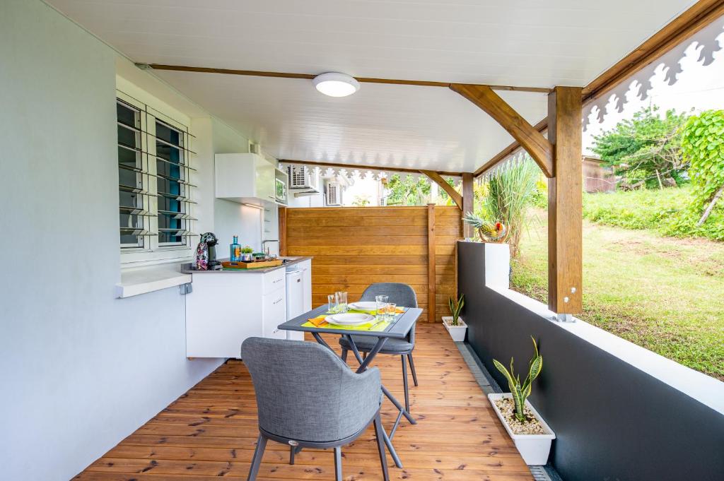 een keuken met een tafel en stoelen op een patio bij Le paradis caché de Phedre in Sainte-Luce