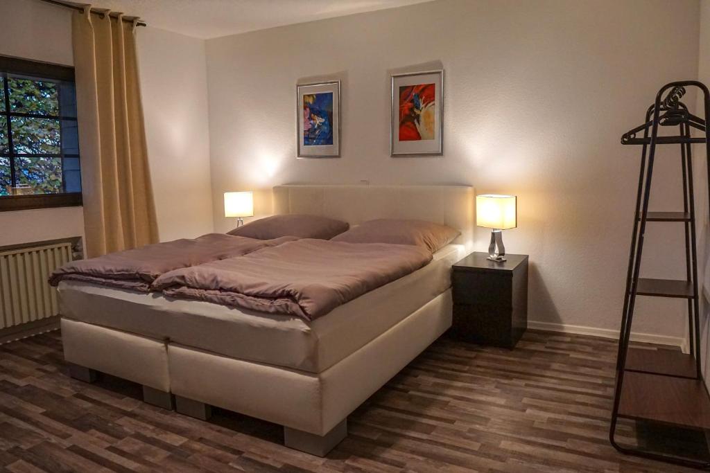 um quarto com uma cama com 2 candeeiros e uma escada em Ferienapartment Christine em Simmerath