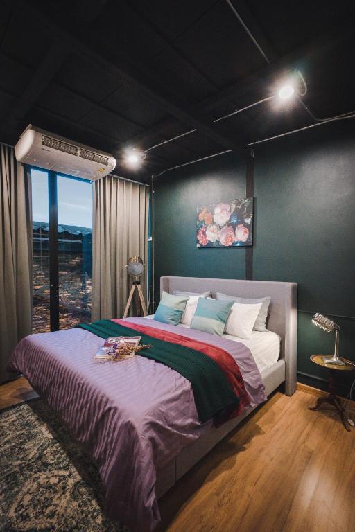 una camera da letto con un letto grande e una finestra di Mojo Old Town Phranakorn a Bangkok