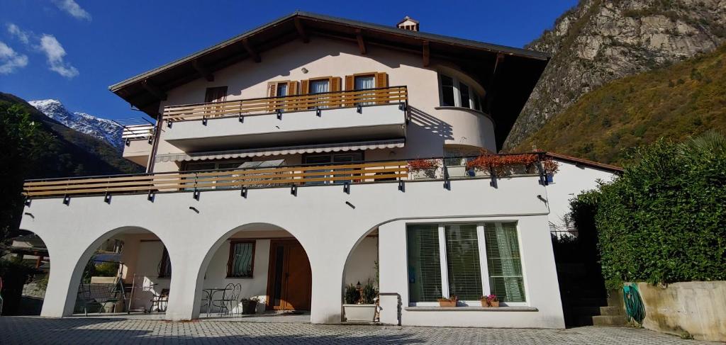 a white house with a balcony on top of it at B&B CAV Rondinella in Chiavenna