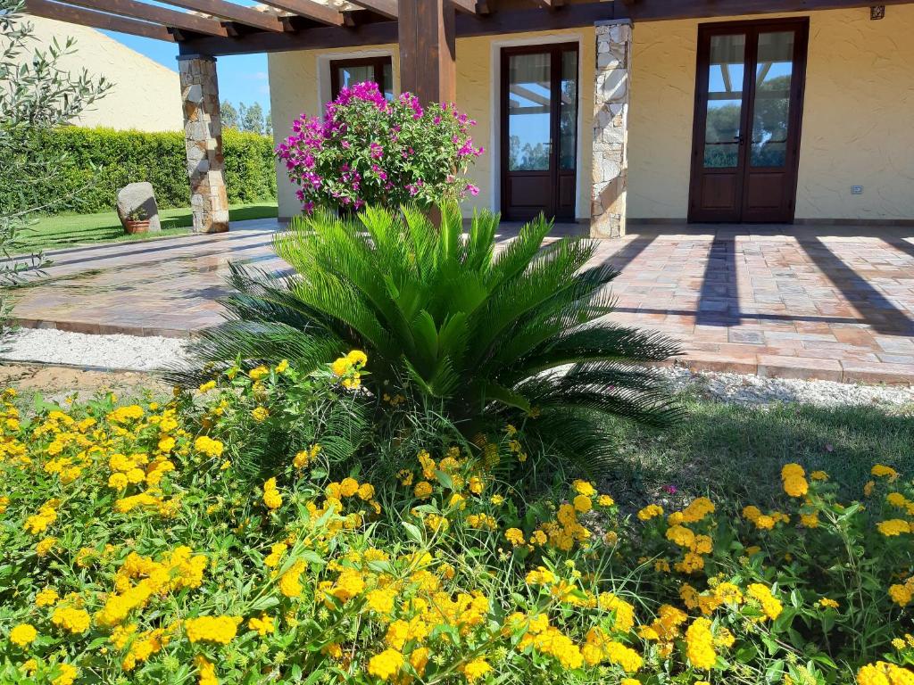 a garden with flowers in front of a house at Agriturismo Is Solinas in Masainas