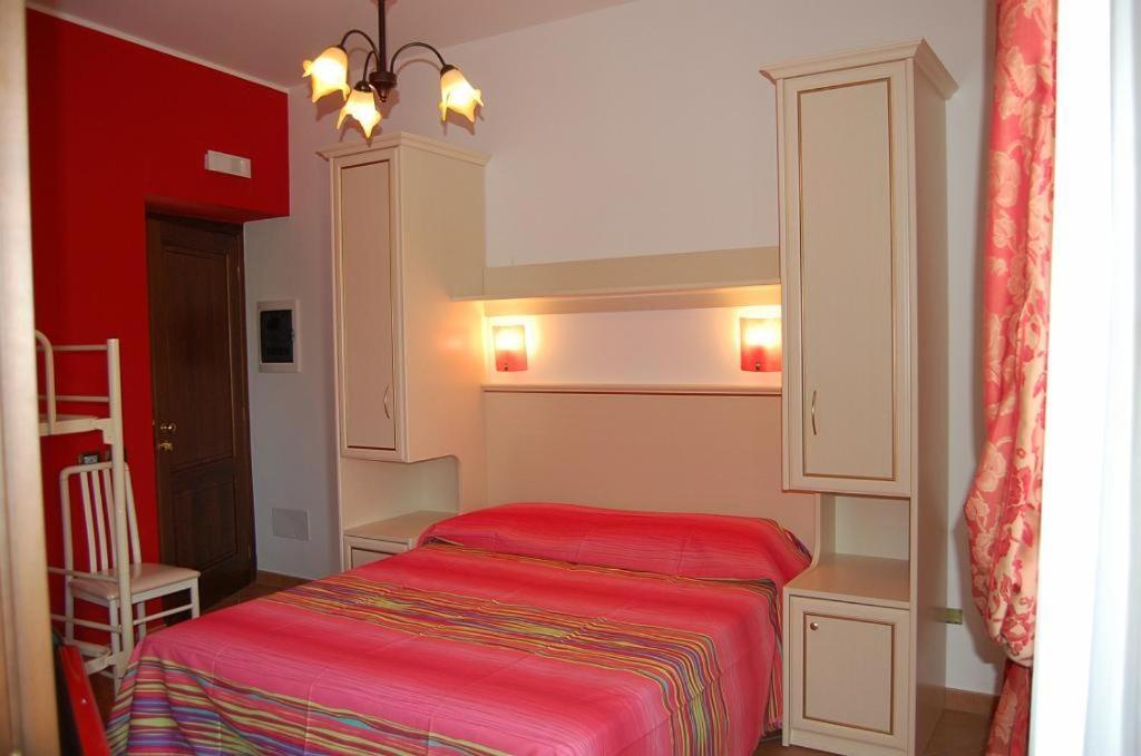 a small bedroom with a red bed in a room at Agriturismo Parra in Santa Lucia del Mela