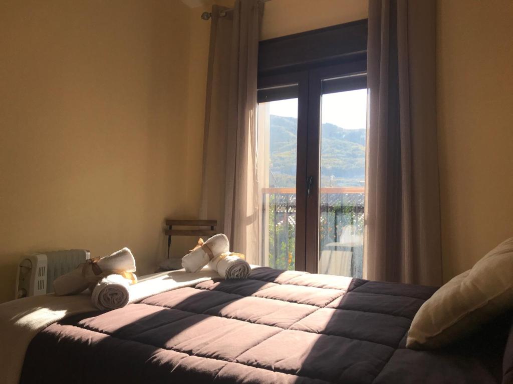 a bedroom with a bed with a large window at LA GARGANTILLA in Jerte