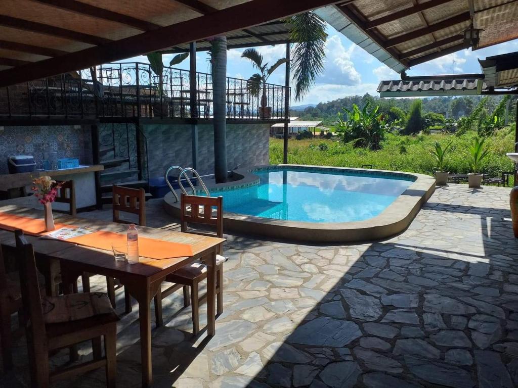 a patio with a pool and a table and chairs at XPai in Pai