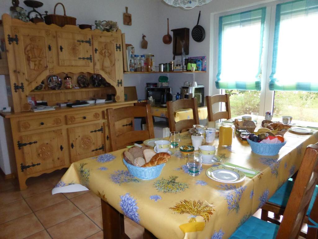 a kitchen with a table with a yellow table cloth at B&B Les Acacias in Le Châble