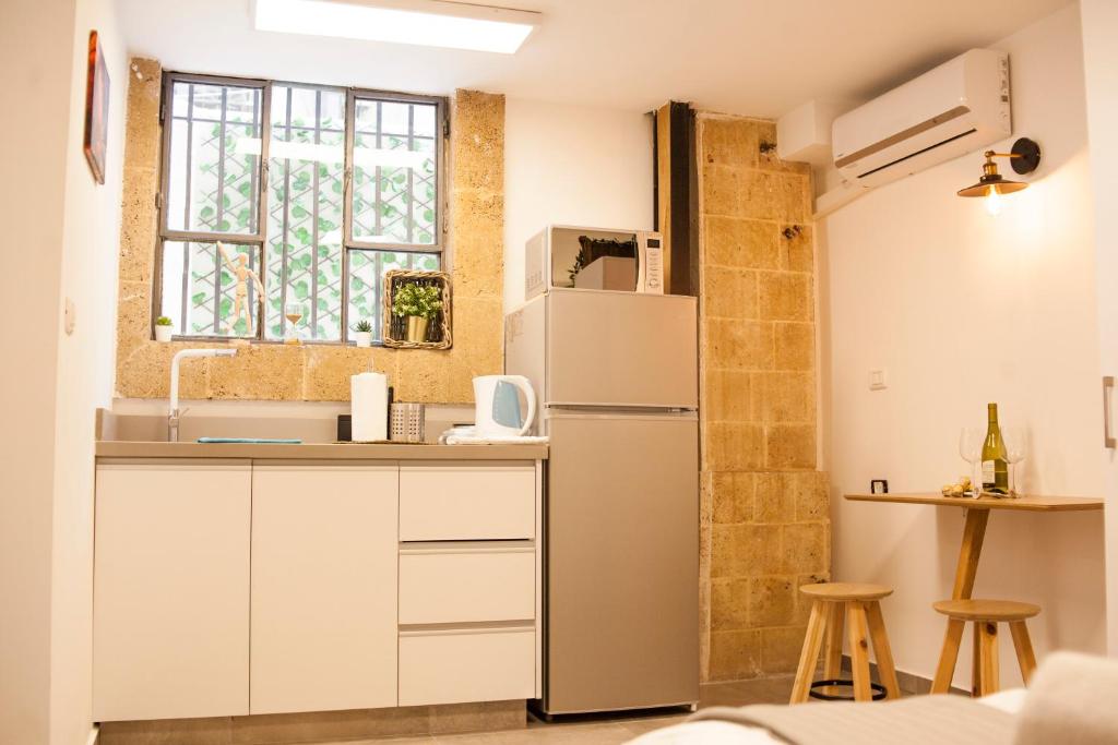 a kitchen with a refrigerator and a window at Locals TLV - Herzl Street in Tel Aviv