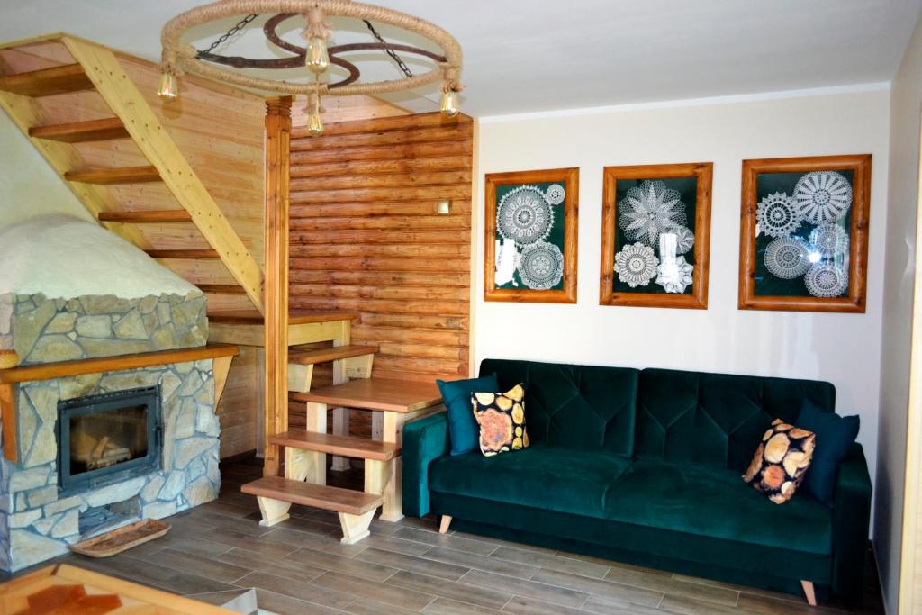 ein Wohnzimmer mit einer grünen Couch und einem Kamin in der Unterkunft Bies Czadowy Zakątek in Ustrzyki Dolne