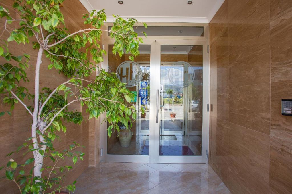 a door to a store with a tree in front of it at Hotel Happy in Battipaglia