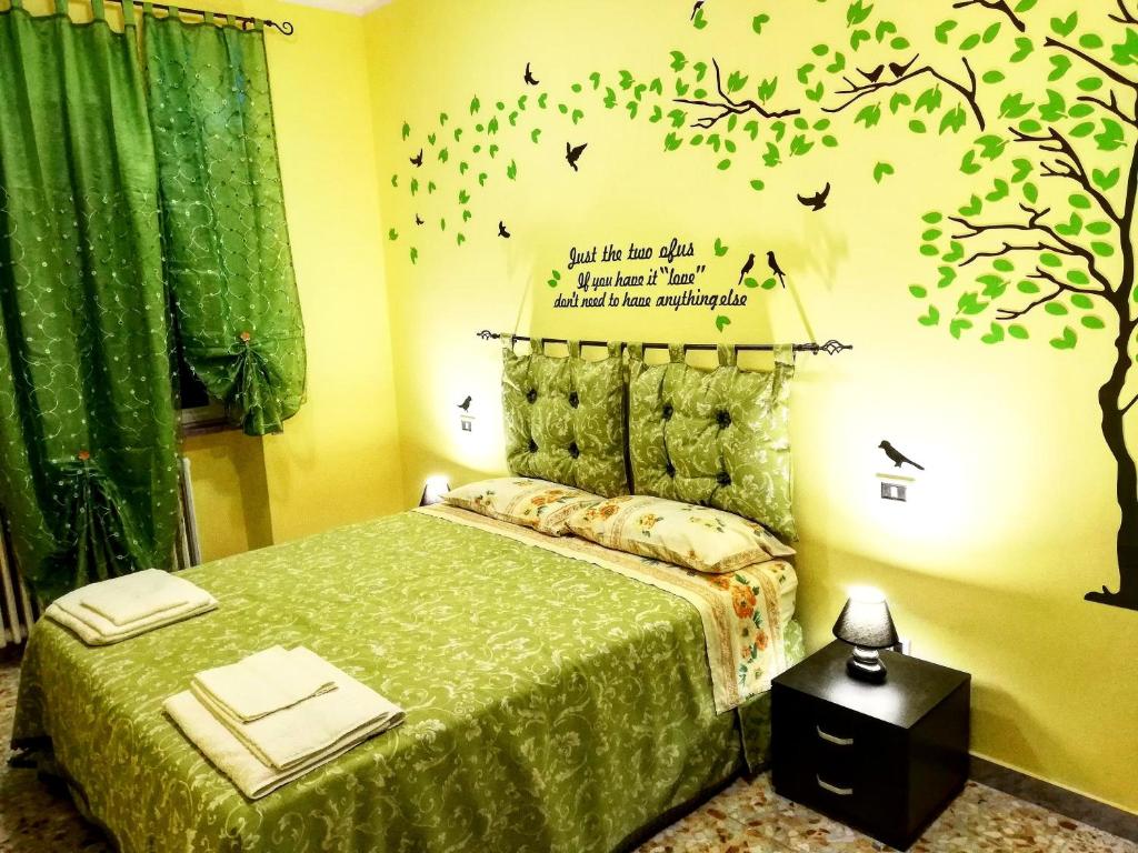 una camera da letto con un letto con un albero e uccelli sul muro di Central Isernia a Isernia
