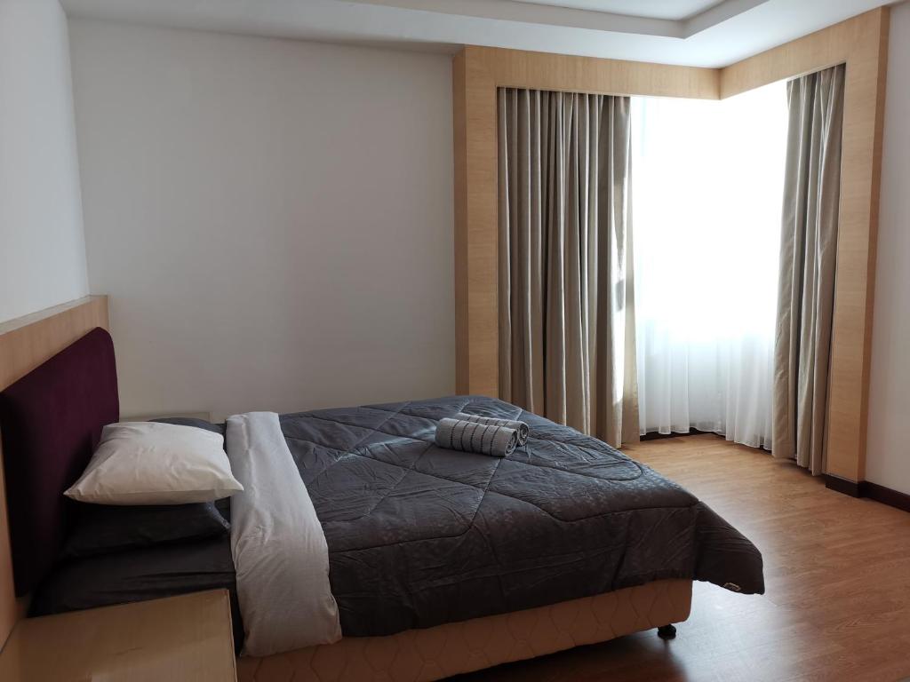ein Schlafzimmer mit einem Bett und einem großen Fenster in der Unterkunft Bernard Holiday Home 2 @ Boulevard Imperial Suite Kuching in Kuching