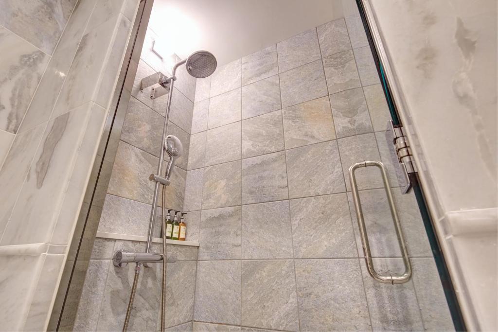 a shower with a glass door in a bathroom at Royal View Hotel Churaumi in Motobu
