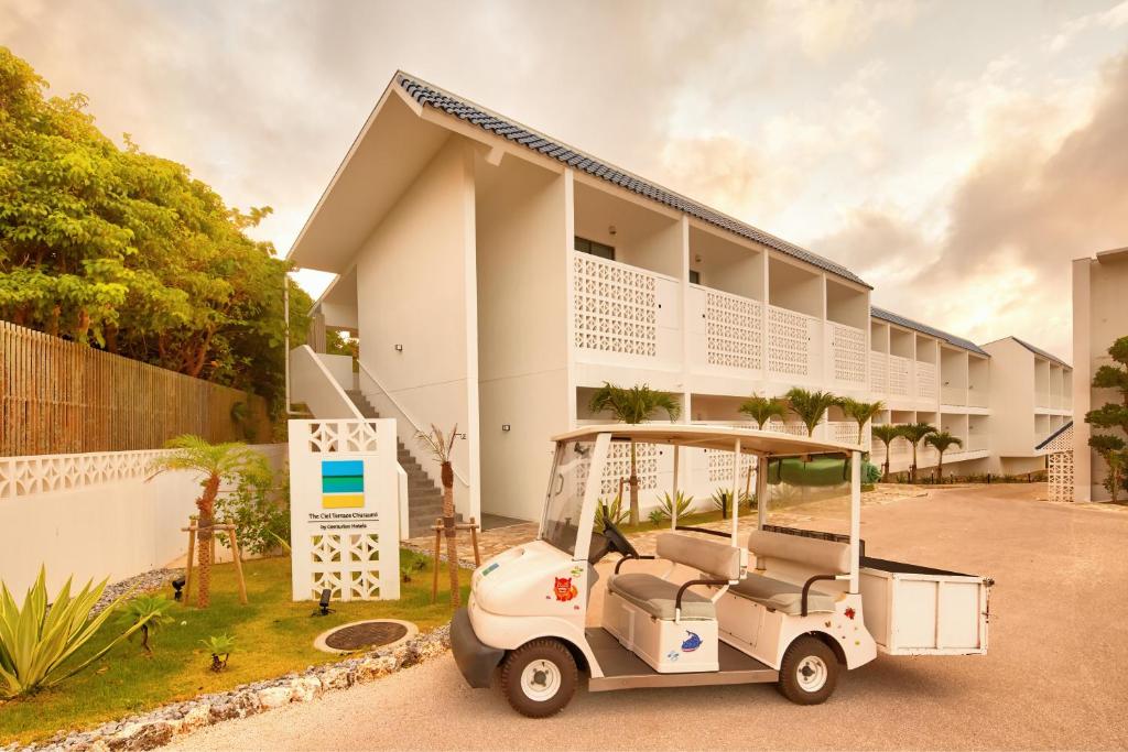 a golf cart parked in front of a building at Royal View Hotel Churaumi in Motobu