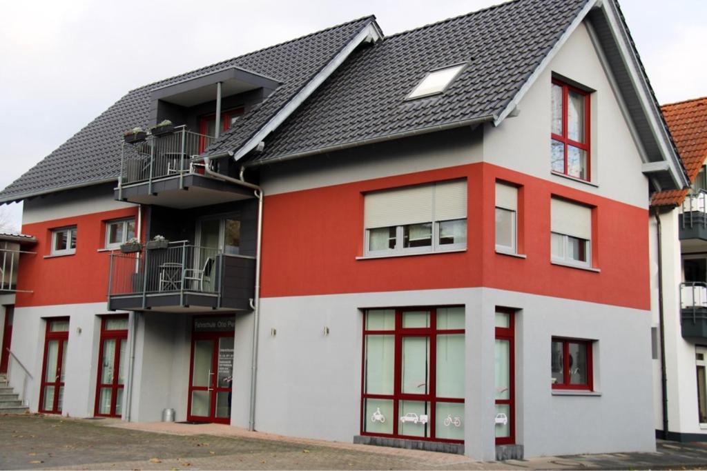 ein rotweißes Gebäude mit schwarzem Dach in der Unterkunft NOX - Bed & Breakfast in Steinheim