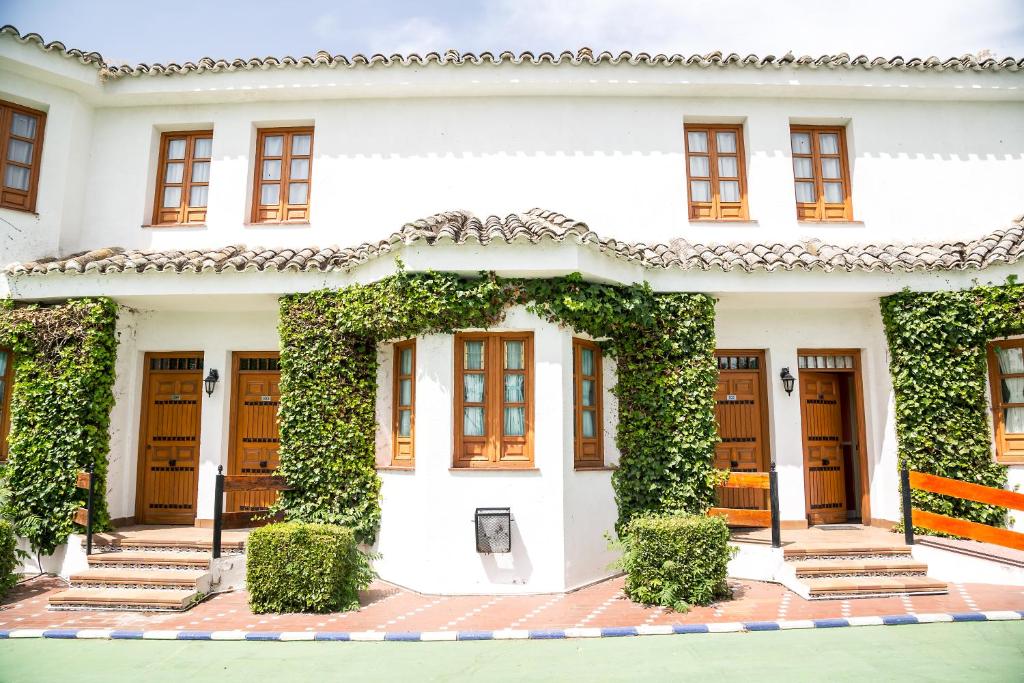 a white house with ivy on it at Los Arcos in Dosbarrios