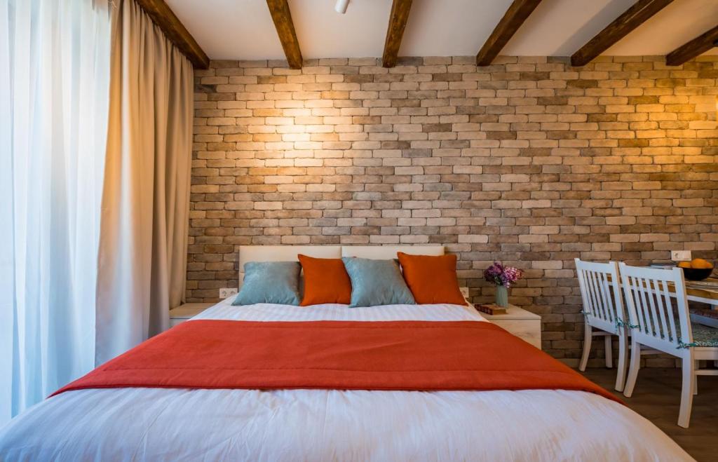 a bedroom with a large bed and a brick wall at New Gudauri Atrium 335 in Gudauri