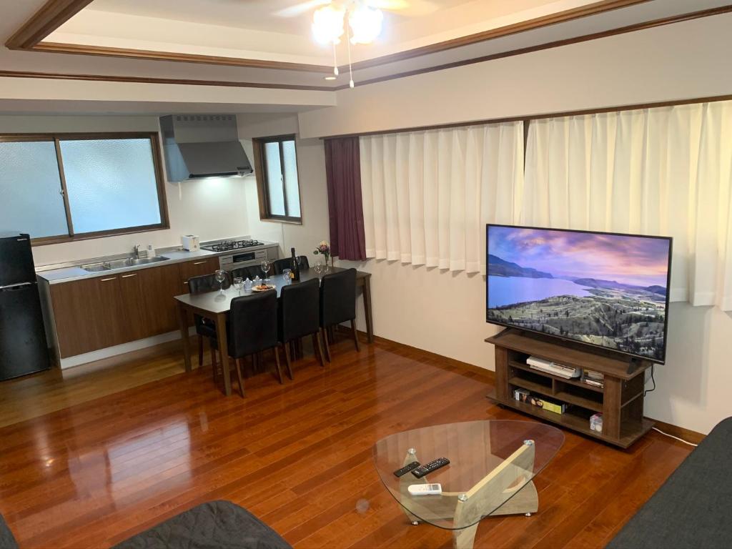 sala de estar con TV de pantalla plana grande en ガナダン中央駅 1f 無料駐車場, en Kagoshima