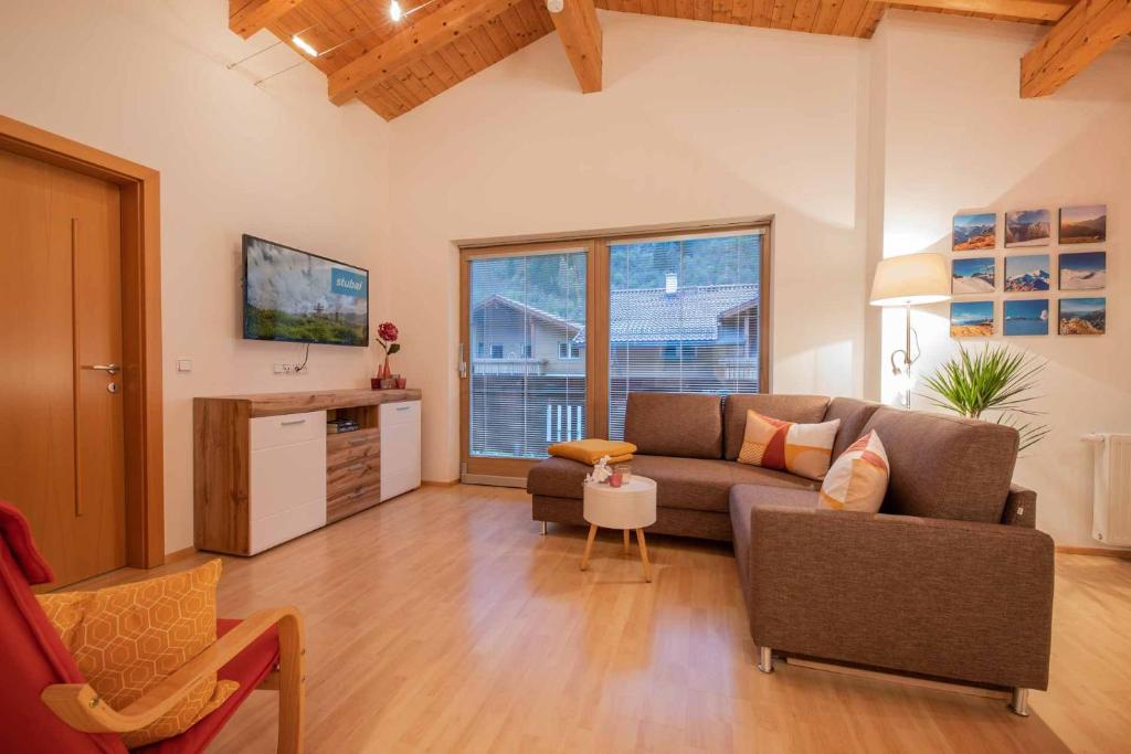 sala de estar con sofá y TV en Ferienwohnung Stern, en Neustift im Stubaital