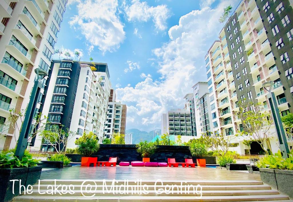 a courtyard in a city with red chairs and buildings at The Lakes at Midhills Genting in Genting Highlands