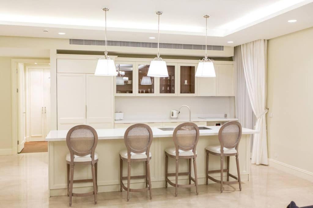 a kitchen with four chairs around a kitchen island at SUITE WA B2 - WALDORF ASTORIA RESIDENCES - JERUSALEM-RENT in Jerusalem