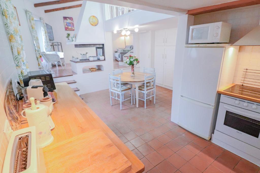 uma cozinha com uma mesa e um frigorífico branco em Duplex au coeur du vieil Antibes em Antibes