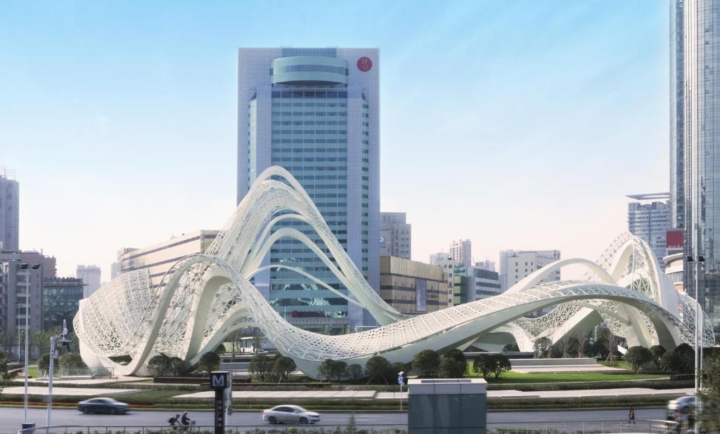 a white bridge in a city with tall buildings at Ramada Plaza Optics Valley Hotel Wuhan (Best of Ramada Worldwide) in Wuhan