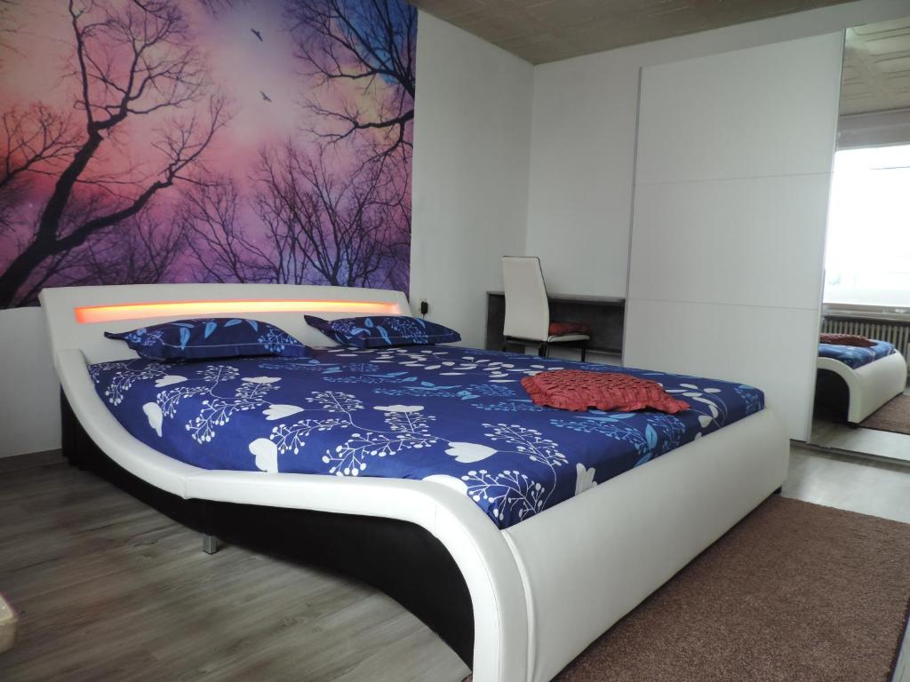 una camera con un grande letto con una parete viola di Your2ndhome-3 a Sindelfingen