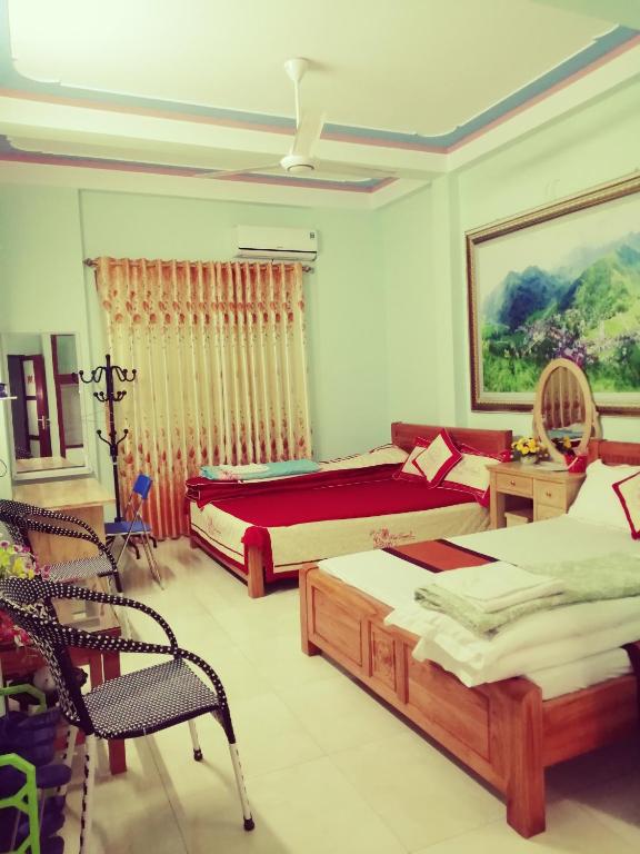 a bedroom with two beds and a desk and a chair at Yen Minh Thien An Motel in Yên Minh