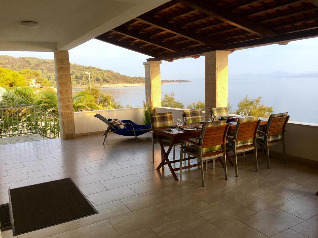 un patio con mesa y sillas y vistas al agua en Schönes Ferienhaus direkt am Meer, en Stomorska