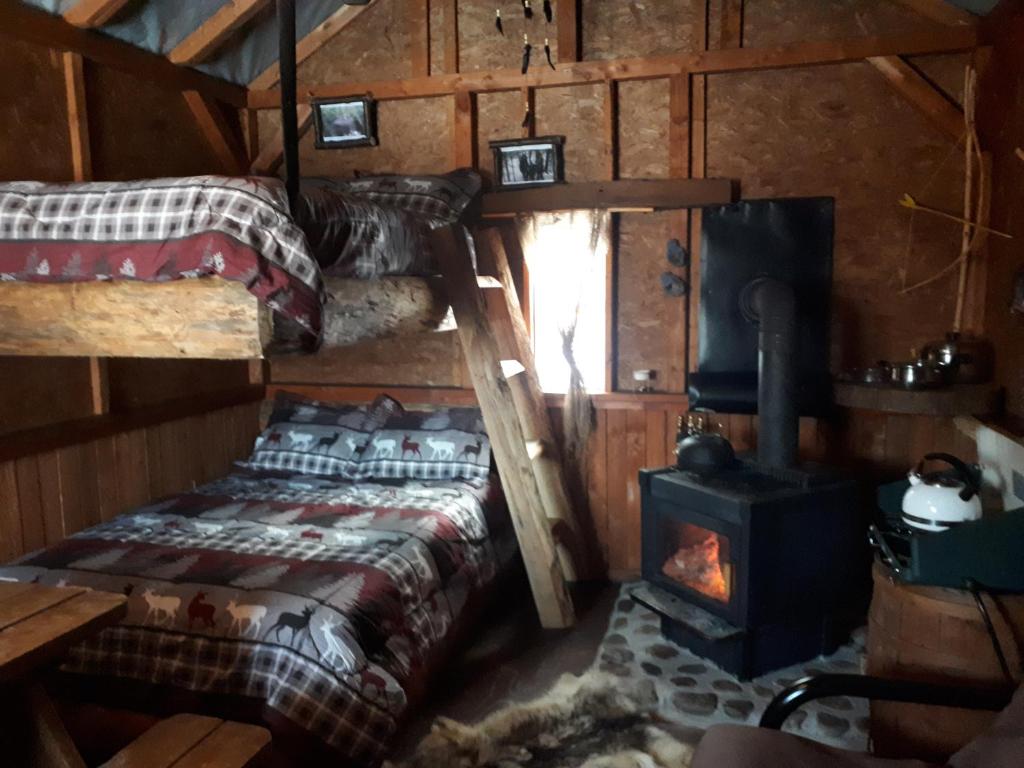 Cette chambre comprend un lit et un poêle à bois. dans l'établissement Hébergement de la Montagne St-Roch, à Saint Roch de Mekinac