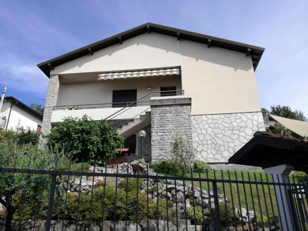ein weißes Haus mit einem Zaun davor in der Unterkunft Appartamento Sari in Como
