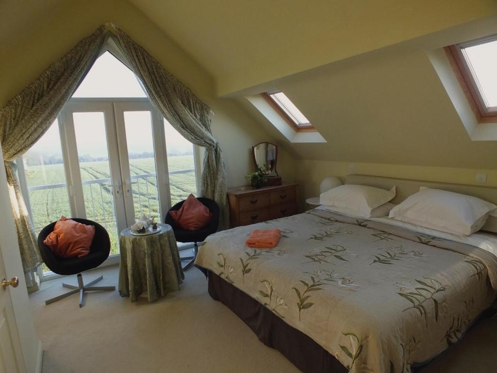 a bedroom with a bed and a large window at Herb Cottage in Bradford on Avon